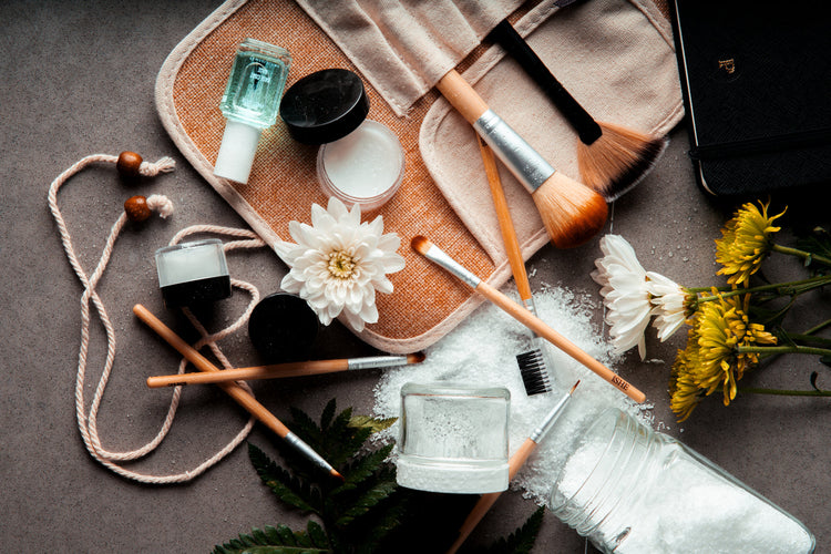 A flatlay of new beauty products on a pale surface