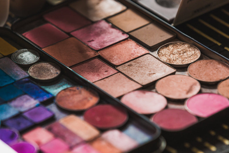 An open palette of eyeshadows and blushes