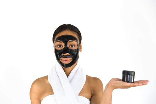 A black activated charcoal peel-off mask being applied