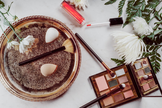 Beauty products arranged beside a fresh flower