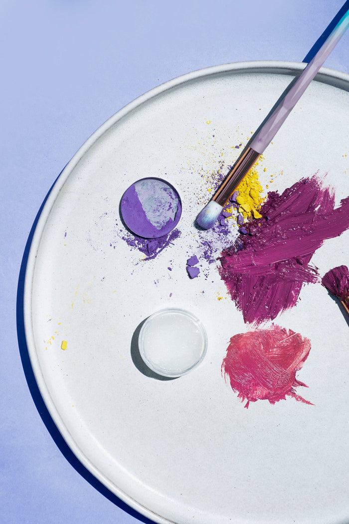 A flatlay of blush and highlighter on a round white plate