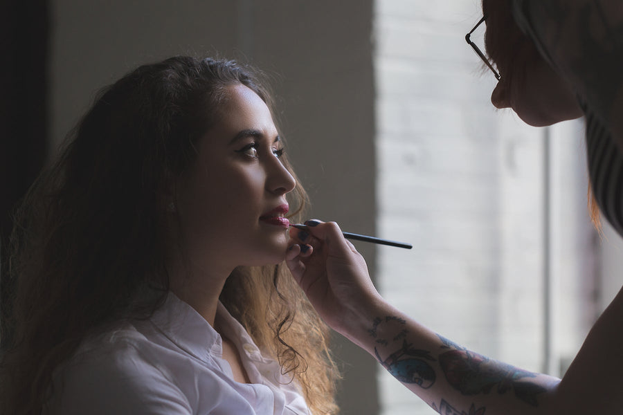 A woman having makeup applied in natural daylight