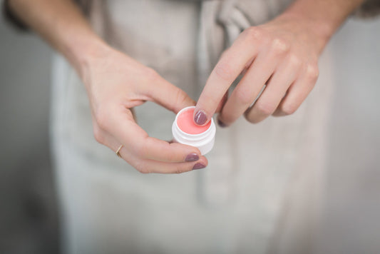A pink tinted lip balm in an open tube