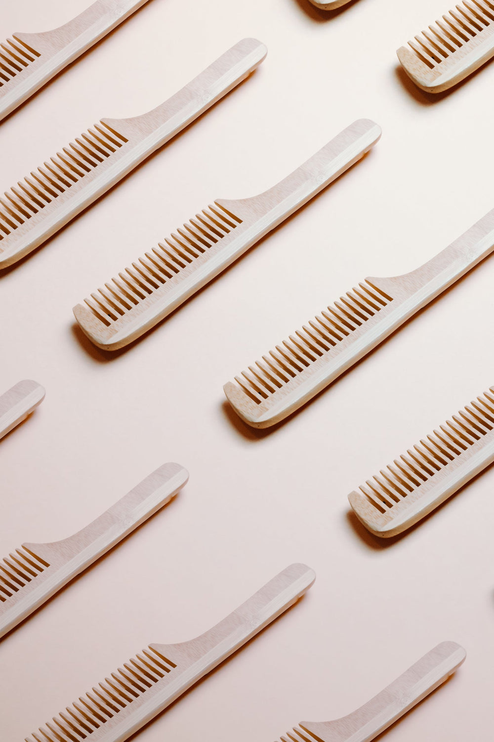Wooden combs laid out on a beige background
